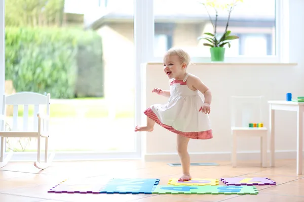 Girl having fun dancing indoors in a sunny white room