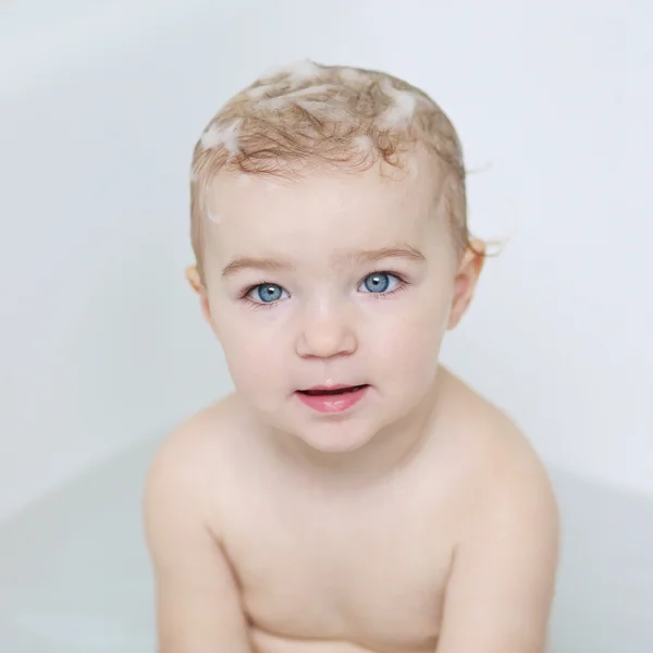 Cute little baby girl sitting in a bath