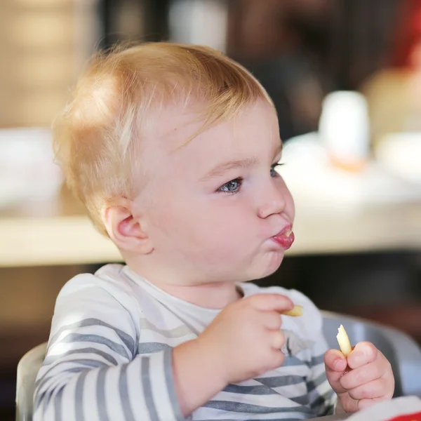 Baby girl eating tasty french fries