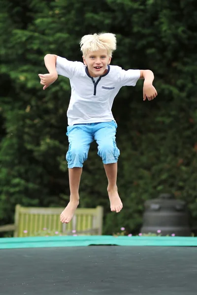Funny boy jumping on trampoline