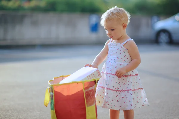 Baby girl taking big shopping bag