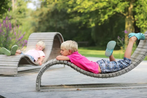 Brothers are chilling out at wooden ergonomic chairs