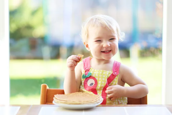 Girl eating delicious pancakes