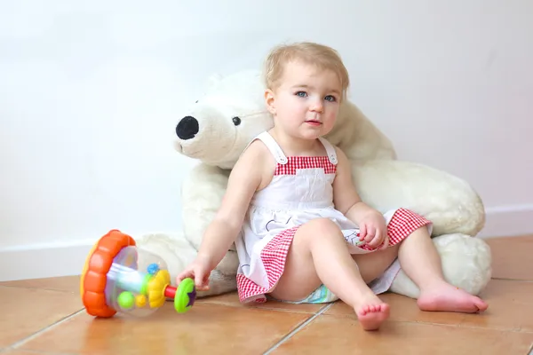 Girl sitting on a big white teddy bear
