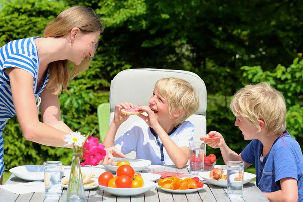 Mother and kids having lunch in the garden