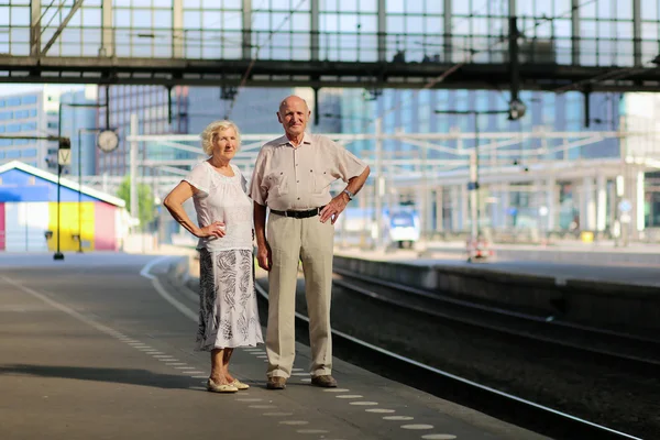 Senior couple waiting for train in railway station