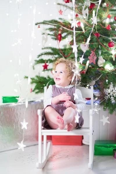 Toddler girl sitting in a white rocking chair