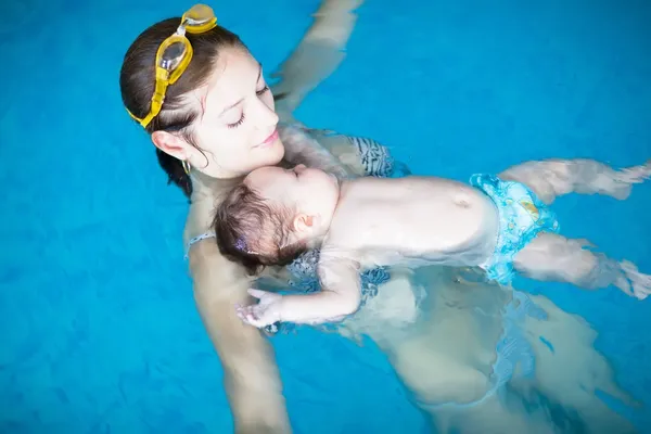 Young baby exercising with his mother