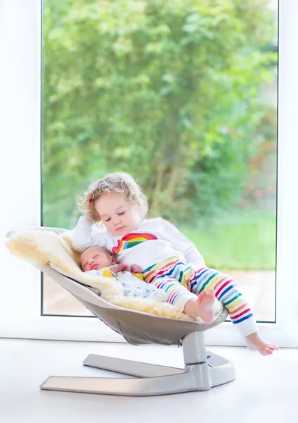 Newborn baby boy and his toddler sister relaxing