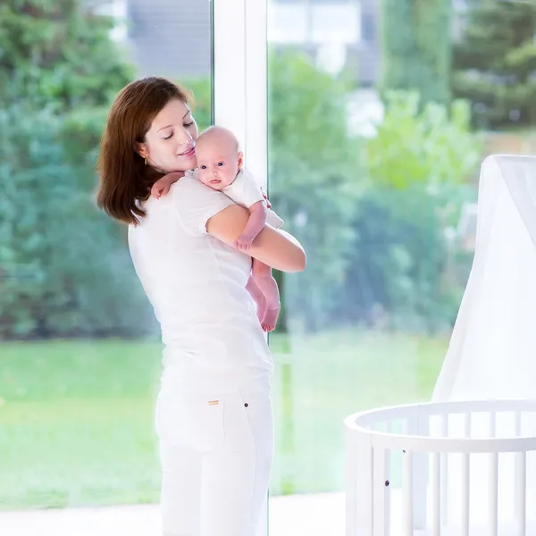 Mother putting her newborn baby to sleep