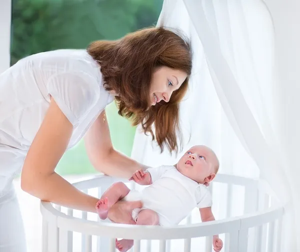 Mother putting her newborn baby to sleep