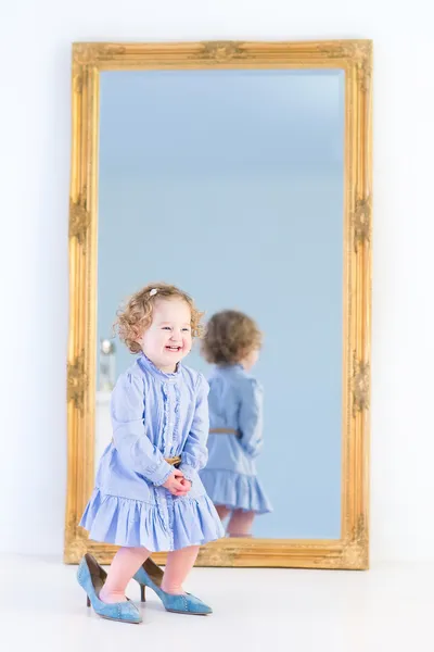 Girl standing in front of a big mirror