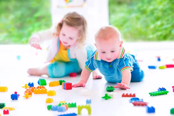 Brother and sister playing with colorful blocks