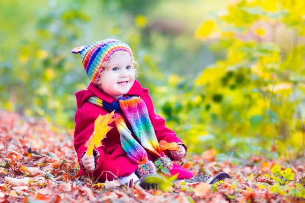 Little girl having fun in an autumn park