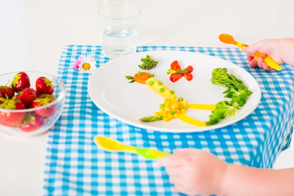 Child\'s hand and healthy vegetable lunch