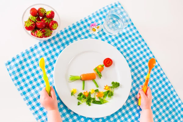 Child\'s hand and healthy vegetable lunch