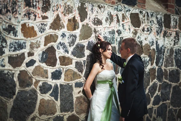 Wedding. husband and wife on the stone wall background