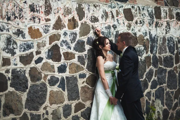 Wedding. husband and wife on the stone wall background