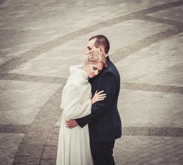 Wedding. bride embraces the groom, and the background of the beautiful background tiles