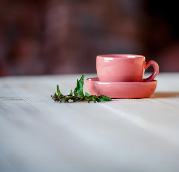 Tea mint in cup with mint leaves on wooden table background. Top view