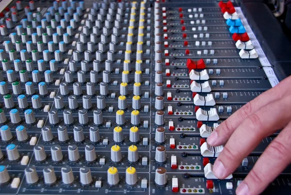 Hand of the sound producer and mixer console