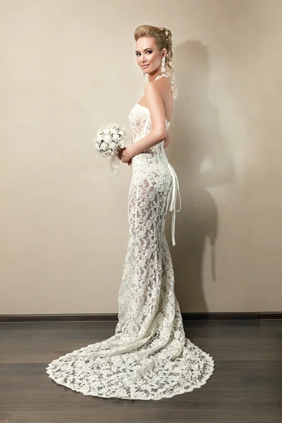 Full length portrait of a beautiful bride holding bouquet