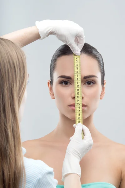 Woman head being measured by beautician hands