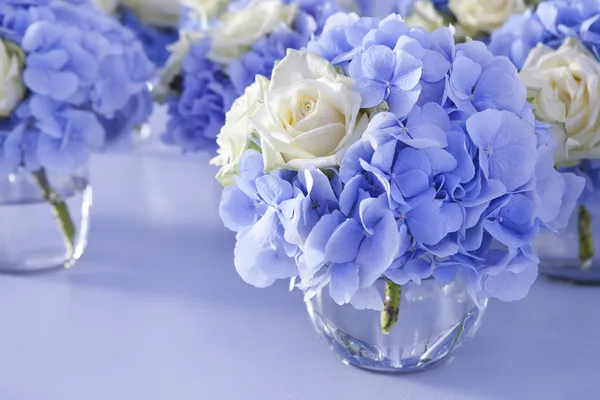 Bouquet of white and blue flower in vase of glass