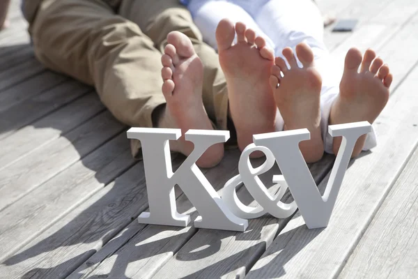 Feet of groom and bride and white love letters