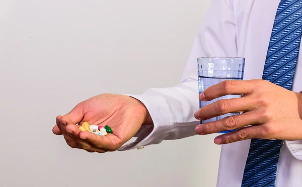 Man holding pills medicine drinking water to eat.