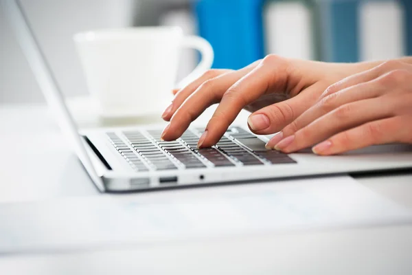 Businesswoman typing on laptop