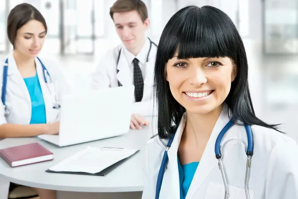 Female doctor standing in frount of his team