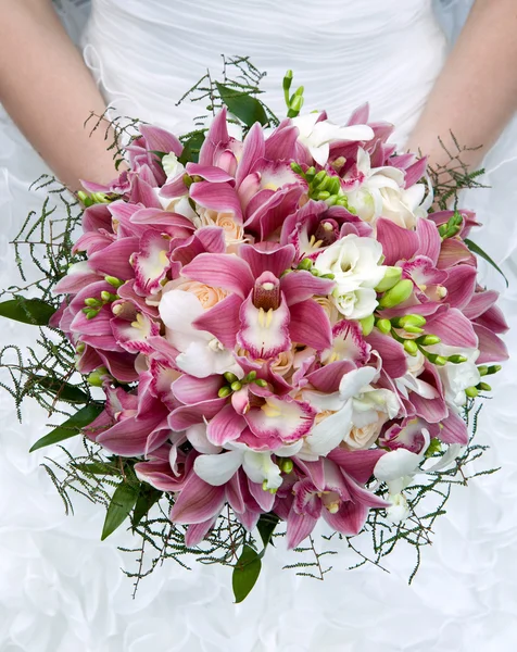 Bouquet of fresh flowers for the wedding ceremony. Bouquet of orchids, roses and other flowers in the bride\'s hands closeup.