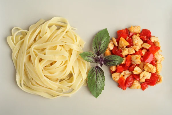 Pasta with grilled chicken and peppers. Chicken Pasta with basil and pepper decorations. Pasta top view.