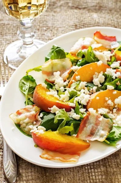 Salad with peaches, bacon, arugula, spinach and goat cheese