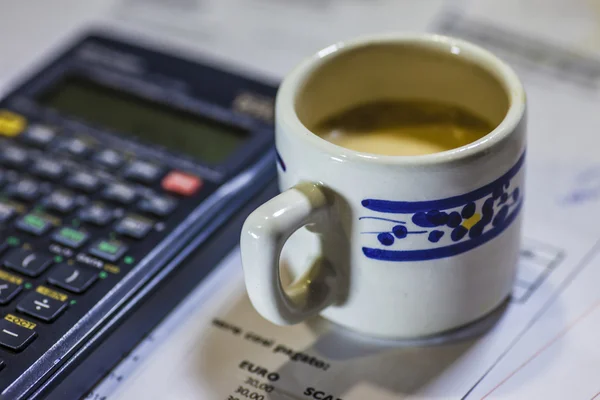 Utility bills, coffee and calculator