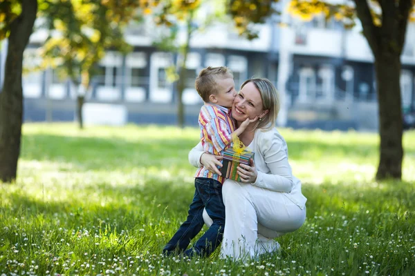 Beautiful boy and mom in spring with present. Mothers day or birthday celebration concept