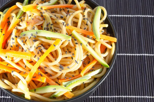 Serving of spaghetti with carrots and zucchini and soy sauce and