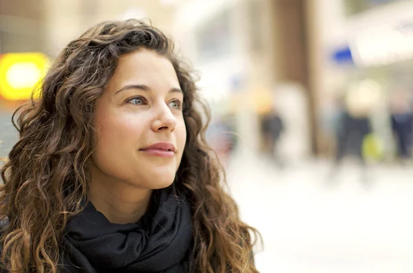 Attractive young woman thinking to herself happily