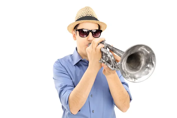 Musician blowing into trumpet