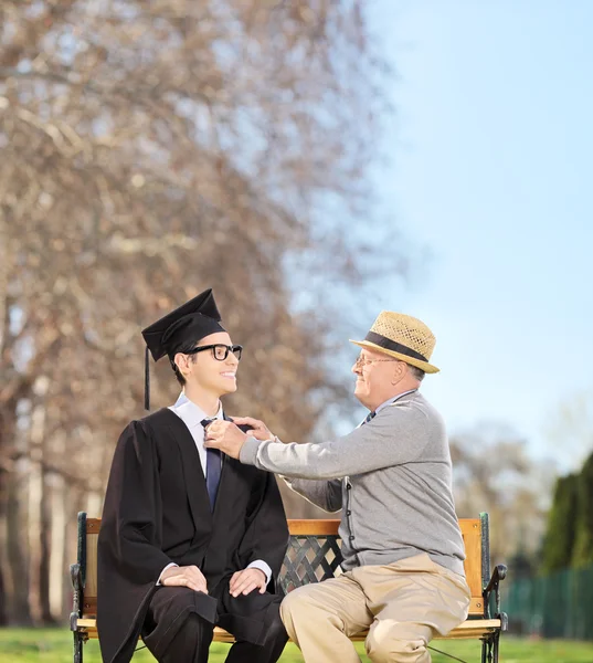 Student and father sitting in park