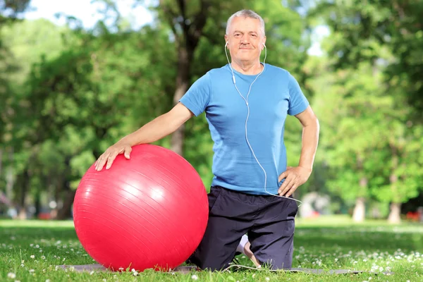 Man with an exercise ball in park