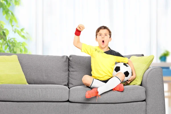 Boy watching football at home