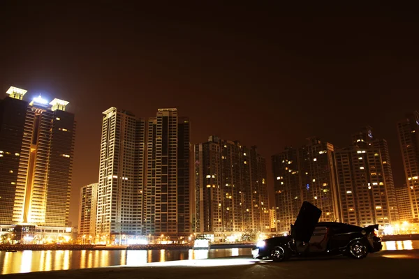 Sports car parked in front of high-rise buildings