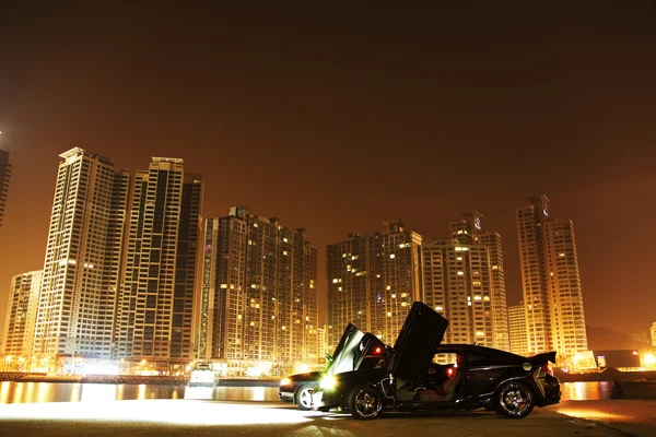 Sports car parked in front of high-rise buildings