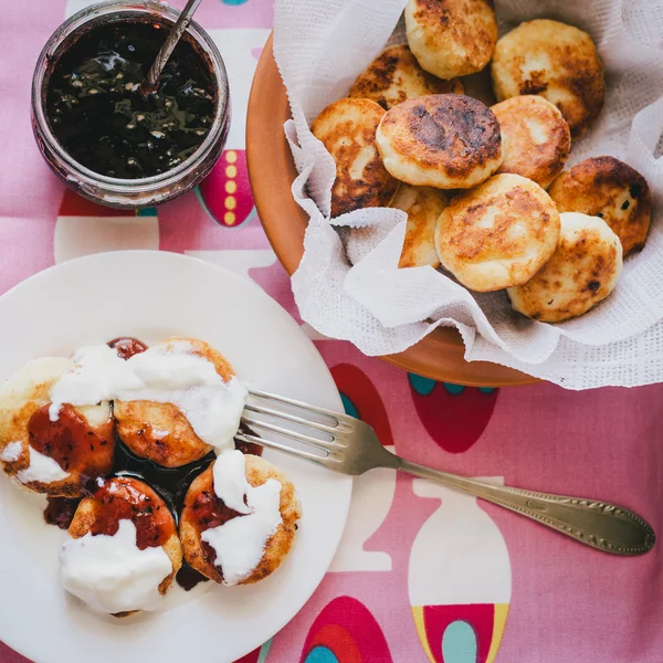 Homemade cottage cheese pancakes with jam and creamy sauce