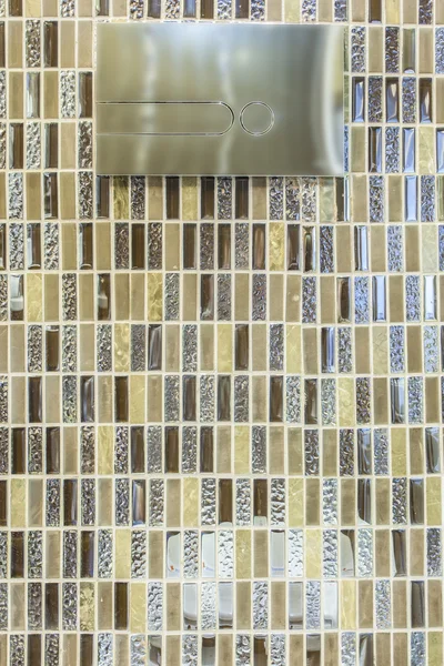 Modern toilet flush buttons and shiny mosaic tiles