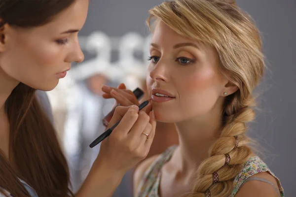 Artist doing professional make up of woman