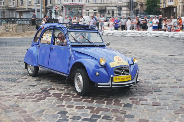 Family driving vintage Citroen 2CV at retro car racing