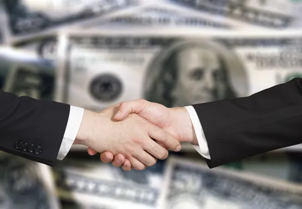 Business handshake on the background of money